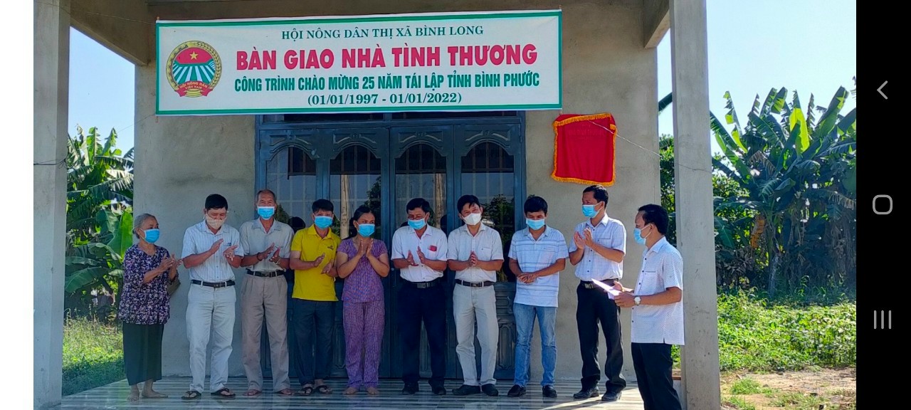 Đ/c Đào Cửu Long - Phó Chủ tịch HND thị xã Bình Long đọc quyết định trao nhà tình thương cho hộ bà Hà Ngọc Bắc