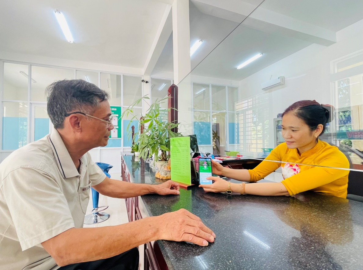 Cán bộ NHCSXH huyện Đồng Phú thực hiện hướng dẫn khách hàng cài đặt và sử dụng VBSP SmartBanking